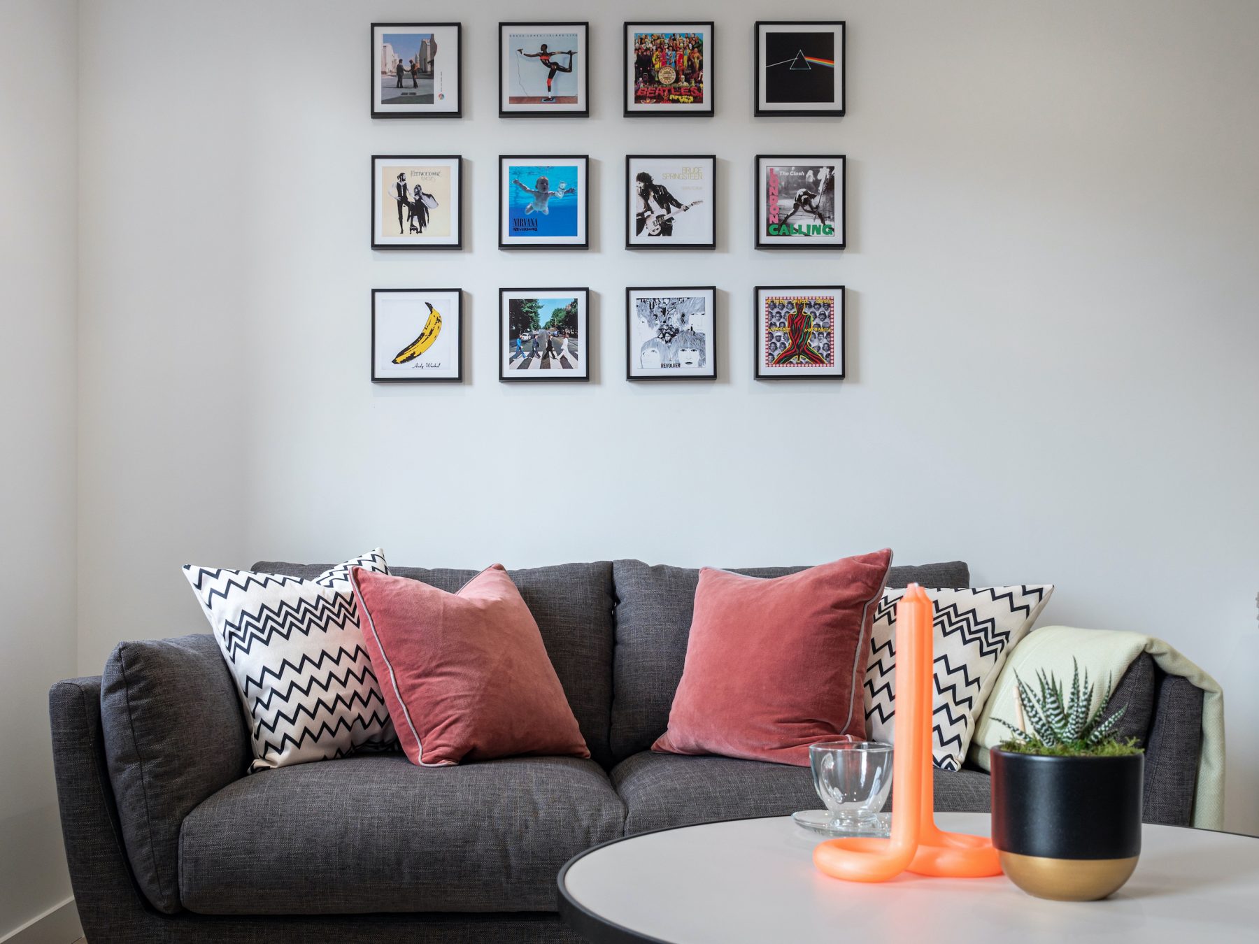 Fika sofa in living room apartment Peckham London coffee table with orange candle and artwork on the wall
