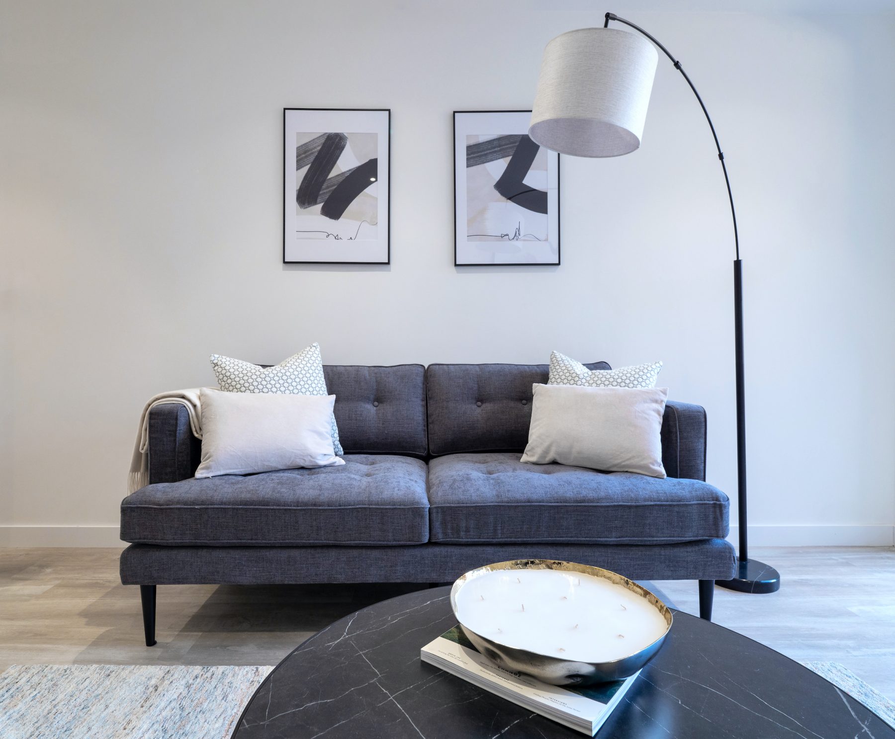 Sleek stylish sofa in room setting with artwork and cushions london apartment